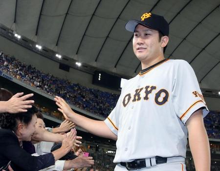 　ヤクルトに勝利し、ファンとタッチを交わす巨人・菅野＝東京ドーム