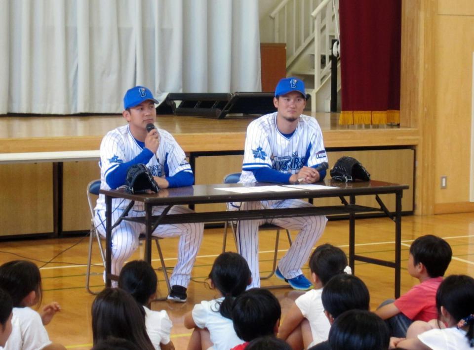 　　訪問授業で小学生にアドバイスを送る山崎康（左）と三上＝横浜市内