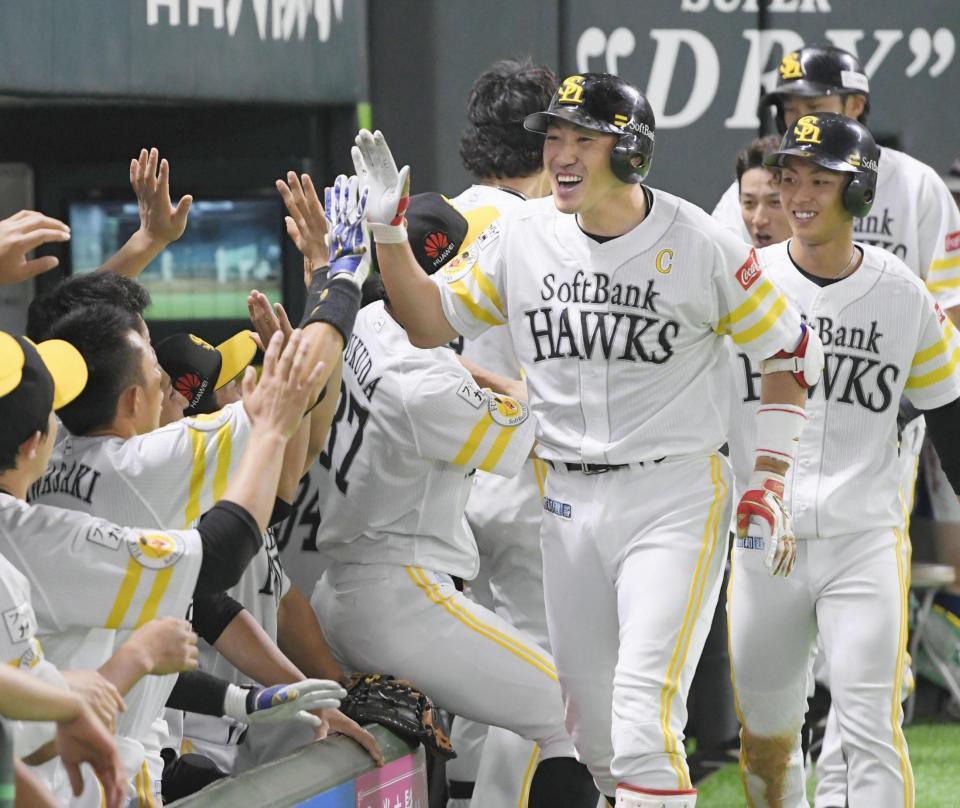 　７回、勝ち越しの満塁本塁打を放ち、ナインに迎えられるソフトバンク・内川（右手前）＝ヤフオクドーム