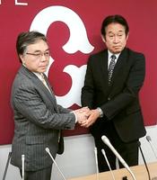 就任会見後、石井球団社長（左）と握手する鹿取ＧＭ