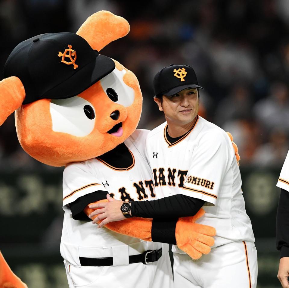 マスコットと抱擁する巨人・高橋監督