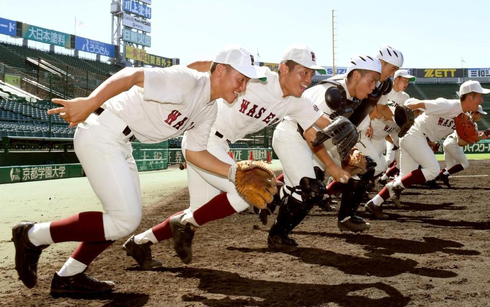 気合いを切れてグラウンドへ駆け出す早稲田佐賀・占部晃太朗主将（左）＝甲子園（撮影・田中太一）