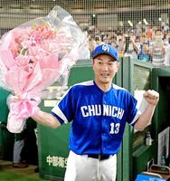 プロ野球タイ記録の９４９試合登板を達成し、花束を掲げる岩瀬（撮影・三好信也）