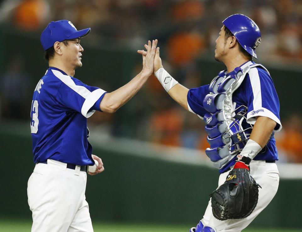 　巨人に勝利し、捕手武山とタッチするプロ野球最多登板記録を達成した中日・岩瀬＝東京ドーム