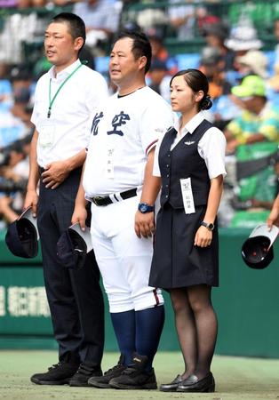 ベンチ前で校歌を聞く日本航空石川・大見謝マネジャー（右）