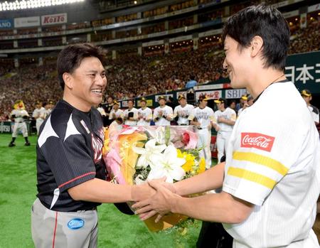 　試合後に和田（右）から花束を贈られ笑顔を見せる井口
