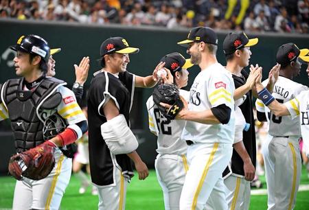 　サファテ（右）からウイニングボールを渡されて笑顔を見せる東浜