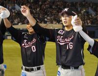 　完封で５勝目を挙げ、ファンの声援に応えるロッテ・涌井（右）と荻野＝ＺＯＺＯマリン