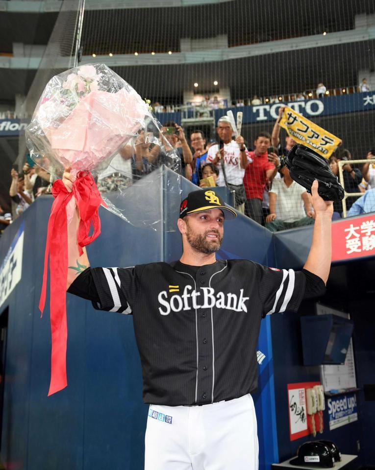 日本記録を達成したサファテは花束を手に笑顔を見せる