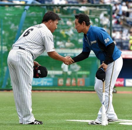 試合前に日本ハム・栗山英樹監督（右）から握手でねぎらわれるロッテ・井口資仁＝ＺＯＺＯマリン（撮影・出月俊成）
