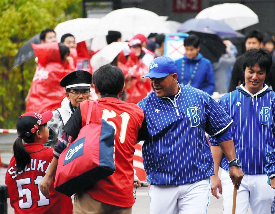 試合前の練習を終え広島ファンとタッチをかわすＤｅＮＡのラミレス監督＝マツダスタジアム（撮影・堀内翔）