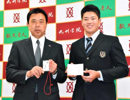 　１位指名のあいさつに訪れた小川監督（左）の横で笑顔を見せる九州学院・村上