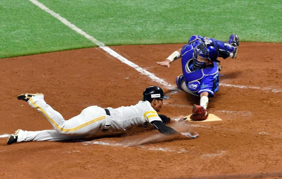 ７回、中村晃の適時打で本塁に突入する今宮（捕手・戸柱）　