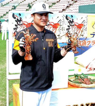 贈呈された伊勢エビを手に笑顔の高橋監督