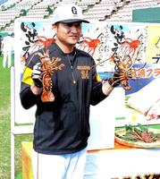 贈呈された伊勢エビを手に笑顔の高橋監督