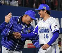 日本シリーズ初勝利で握手するＤｅＮＡのラミレス監督（左）と浜口＝横浜スタジアム（撮影・堀内翔）