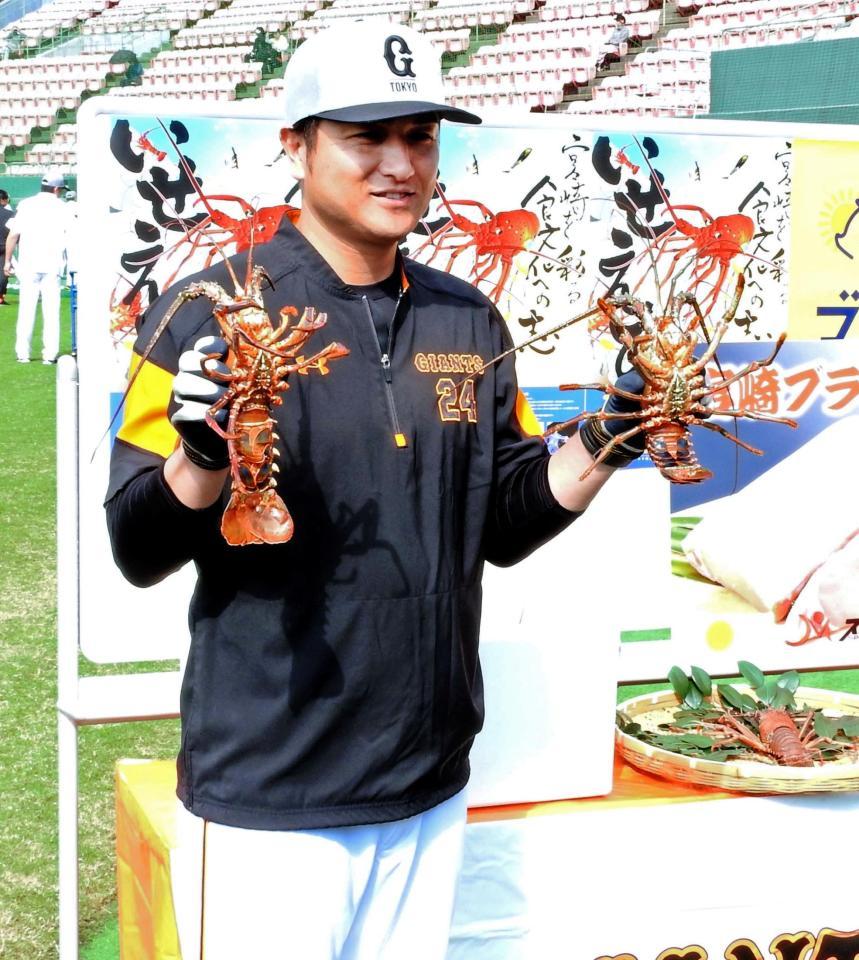 贈呈された伊勢エビを手に笑顔の高橋監督