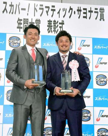 　スカパー！ドラマティック・サヨナラ賞の年間大賞に選ばれ、トロフィーを手にする栗山（左）と宮崎