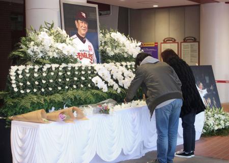 　４日に死去した星野仙一氏をしのび、楽天生命パーク宮城に設けられた献花台に花を手向ける人たち＝７日午後、仙台市