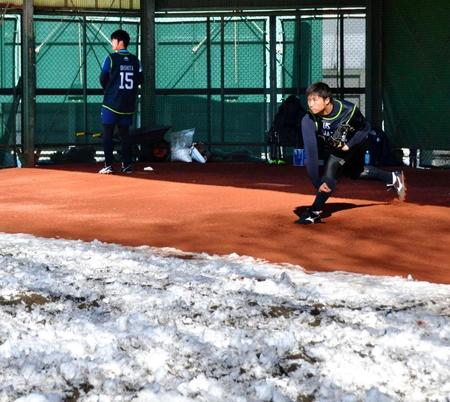 　雪が残るブルペンで投球練習を行う沼田（右）と大下