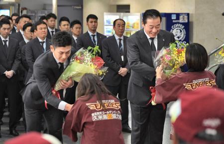 　久米島空港に到着し、歓迎セレモニーで花束を受け取る楽天の梨田監督（右）＝３０日