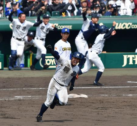 ９回明徳２死一、二塁、中越えサヨナラ３点本塁打を放ちガッツポーズの谷合と沸き上がる明徳ベンチ＝甲子園（撮影・持木克友）