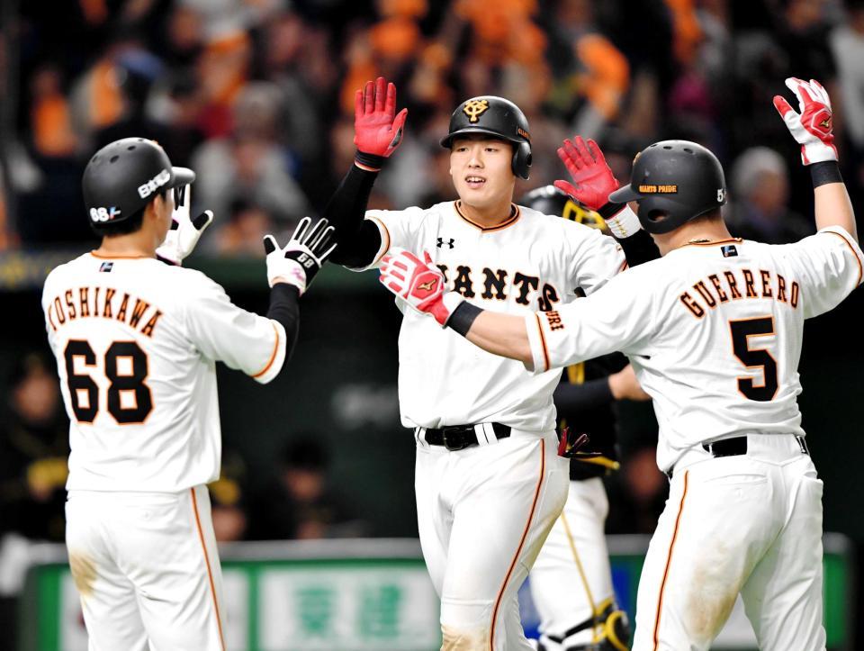 　８回、左中間に３ランを放ち、吉川大（左）、ゲレーロ（右）に祝福される岡本＝撮影・西岡正