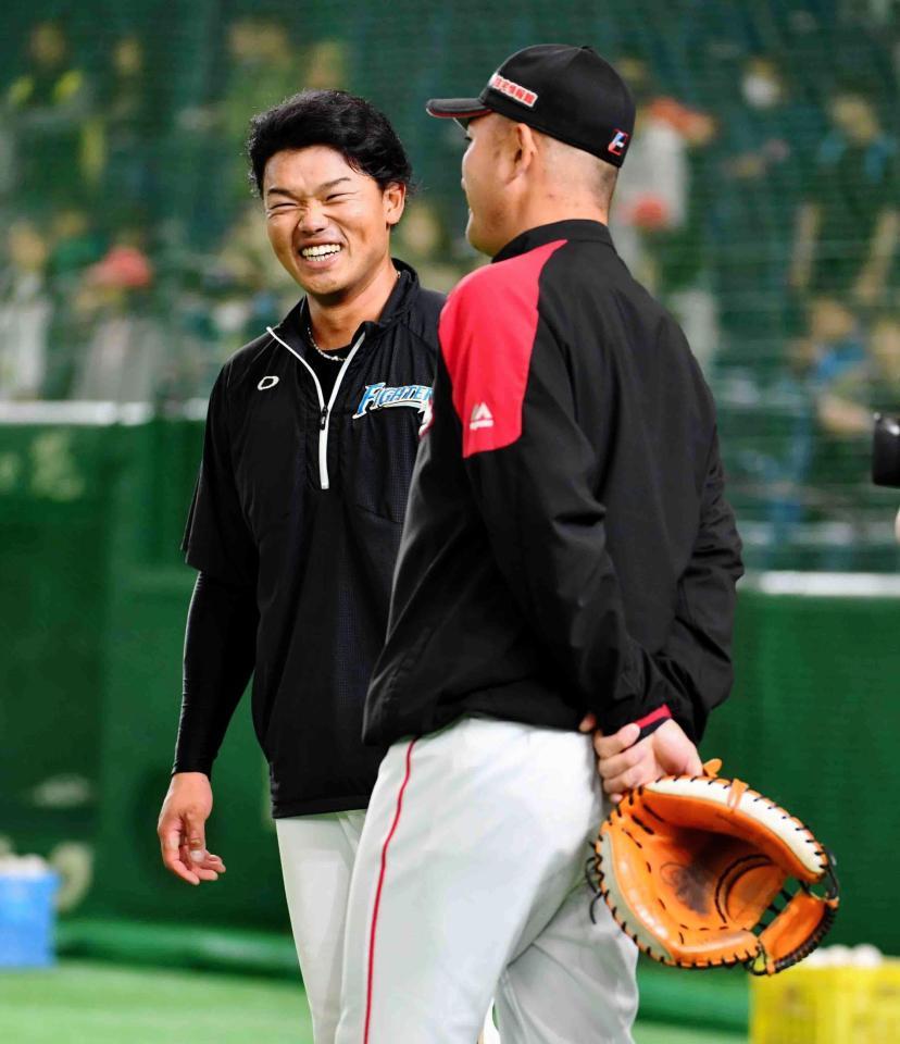 今季初の１軍に昇格した日本ハム・大嶋匠（左）は笑顔でロッテ・的場コーチと話をする＝東京ドーム（撮影・中田匡峻）