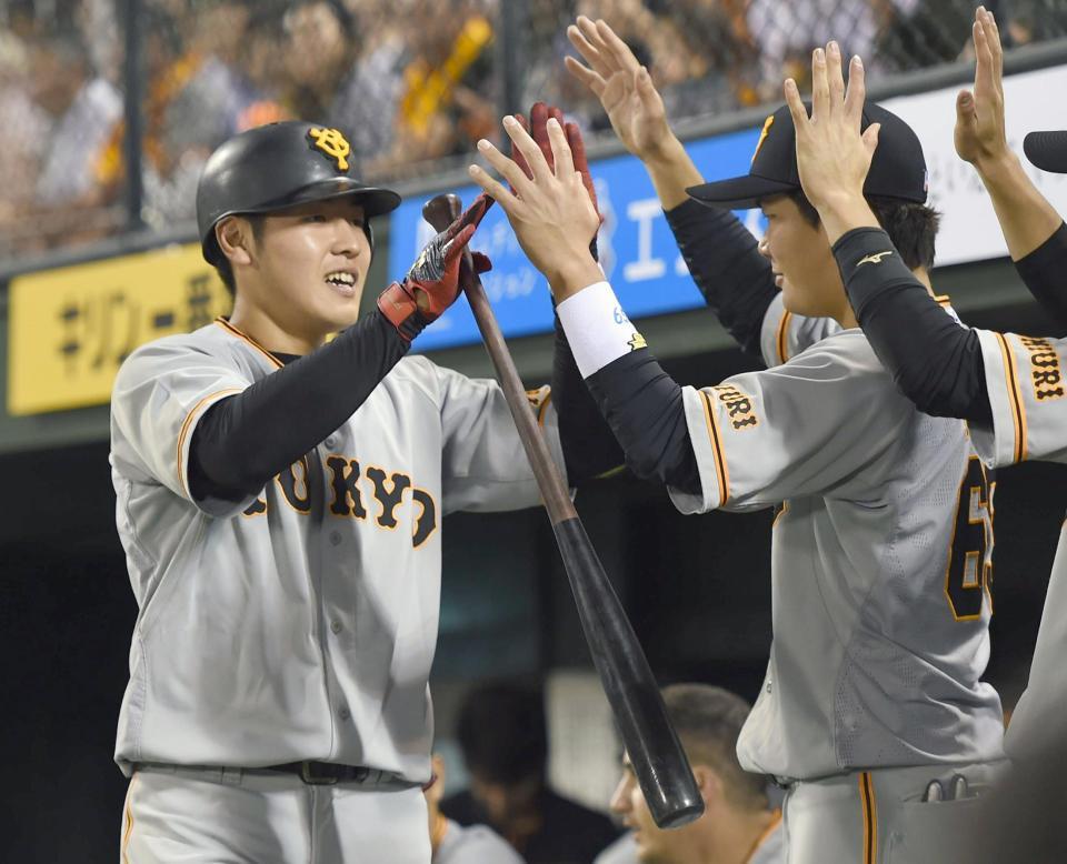 　４回、同点ソロを放ちナインに迎えられる巨人の岡本（左）