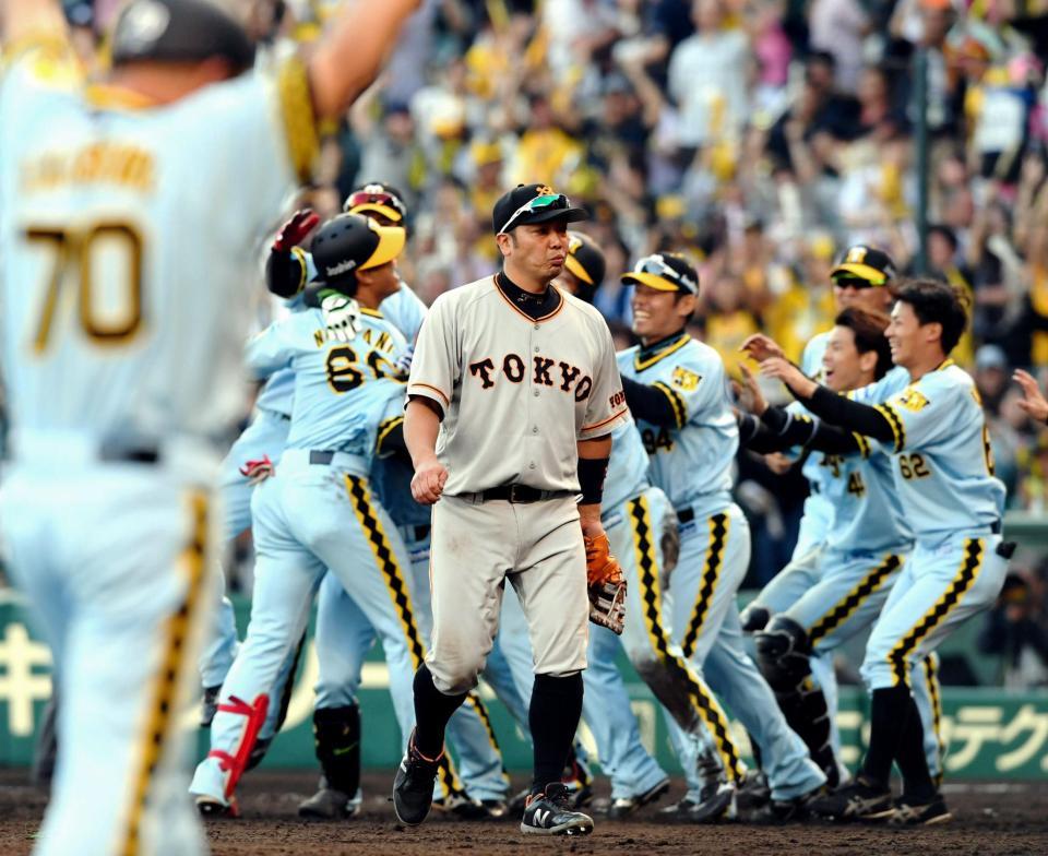 ９回、歓喜に沸く阪神ナインを背にベンチへ戻る巨人・阿部慎之助＝甲子園（撮影・田中太一）