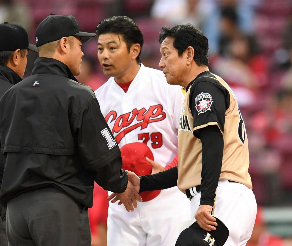メンバー表を交換する日本ハム・栗山英樹監督と広島・緒方孝市監督＝マツダスタジアム（撮影・飯室逸平）