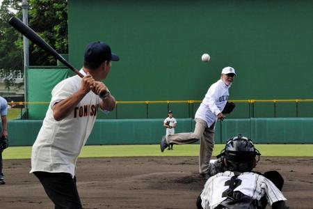 第１００回全国高校野球選手権記念沖縄大会開幕戦前に始球式で投球する安仁屋氏と、打者・石嶺氏（左）＝沖縄市のコザしんきんスタジアム