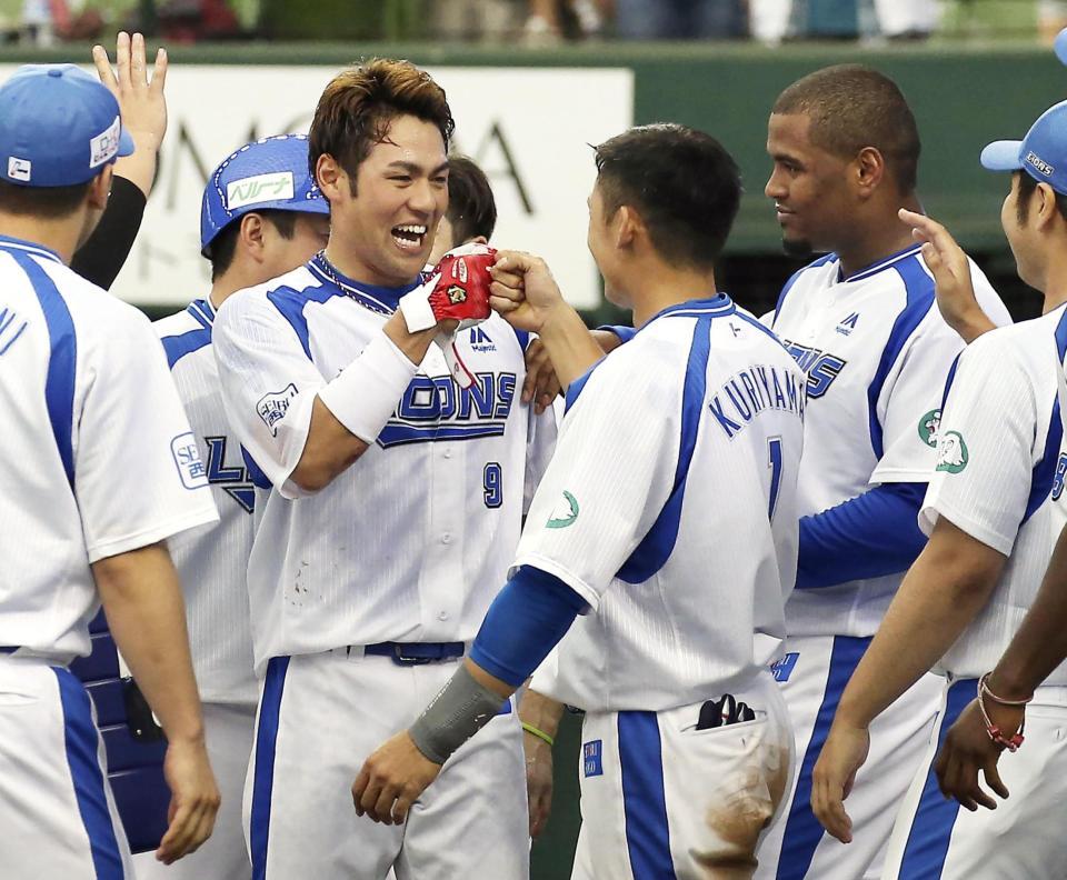 　９回、サヨナラ本塁打を放ち、栗山と笑顔でタッチを交わす西武・木村（中央左）＝メットライフドーム