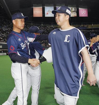 　５勝目を挙げ、辻監督（左）と握手する西武・十亀＝札幌ドーム