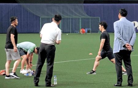 球場近くの店舗で購入したトレーニングウエアと靴を身に付け、調整を行う石川（左）と小川（右から２人目）ら