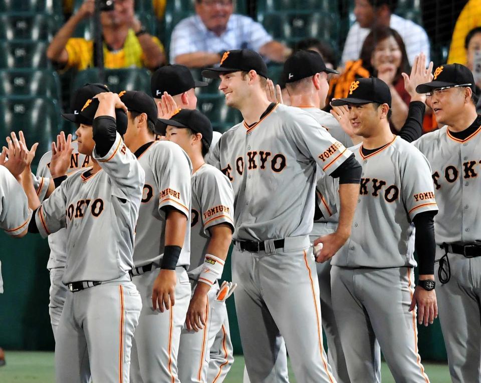 　ウイニングボールをポケットにしまいながらナインとタッチを交わすヤングマン（中央）＝撮影・高部洋祐