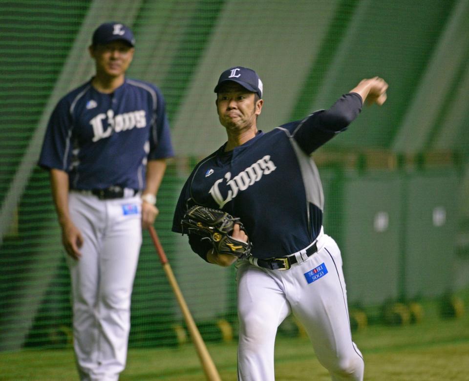 土肥コーチの見守る中キャッチボールをする西武・榎田（右）