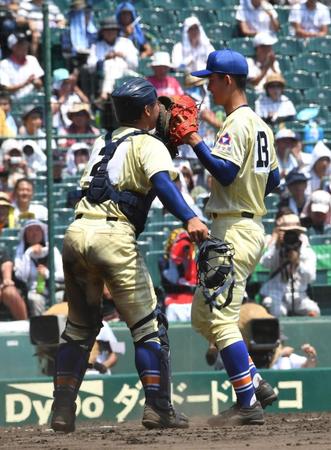 ９回から登板し１イニングをピシャリと抑え山瀬捕手（左）とタッチを交わす寺西＝甲子園（撮影・持木克友）