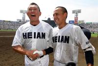 龍谷大平安・原田監督（左）はサヨナラ打を放った龍谷大平安・安井と笑顔で握手する＝甲子園（撮影・山口登）