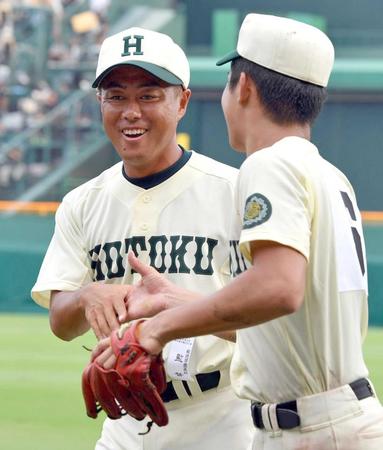 　初戦突破し小園（右）と握手する報徳学園・大角監督