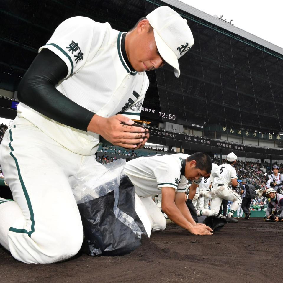 浦和学院に敗れグラウンドの土を集める二松学舎大付の岸川