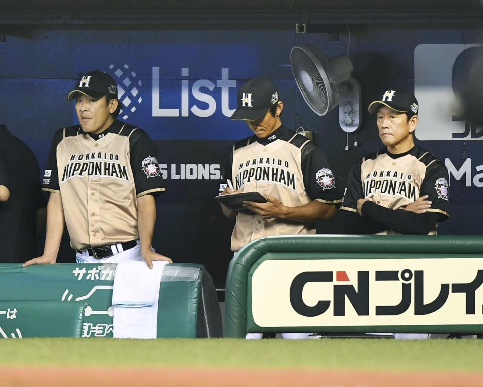 　西武に逆転負けを喫し、さえない表情の日本ハム・栗山監督（右）ら＝メットライフドーム