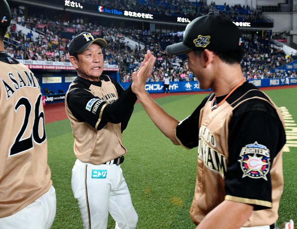 ロッテに勝利しらナインとハイタッチを交わす日本ハム・栗山英樹監督（左）＝ＺＯＺＯマリンスタジアム（撮影・棚橋慶太）