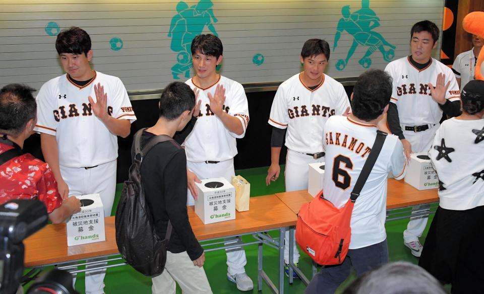 試合前に北海道胆振東部地震の被災地支援募金に訪れたファンとタッチを交わす（左から）巨人・菅野、小林、石川、上原＝東京ドーム（撮影・堀内翔）