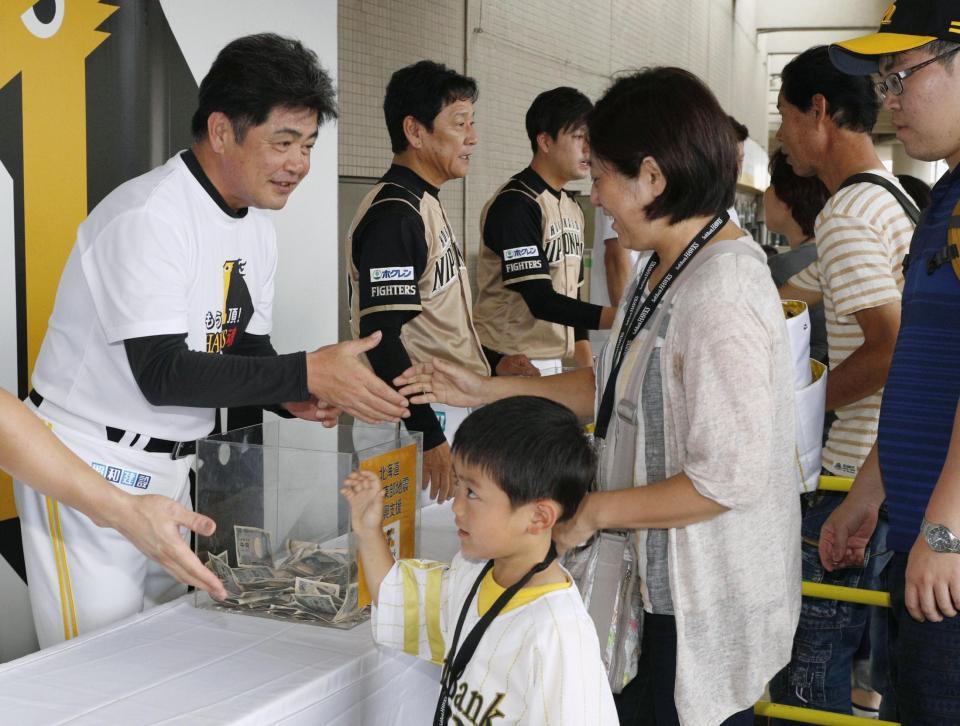 　北海道の地震の被災地支援で募金活動する（左から）ソフトバンクの工藤監督と日本ハムの栗山監督