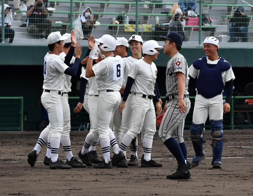 ９回、サヨナラの左前適時打を放ちナインに迎えられる日置（６）と打たれた敦賀気比・坂井＝福井県営球場