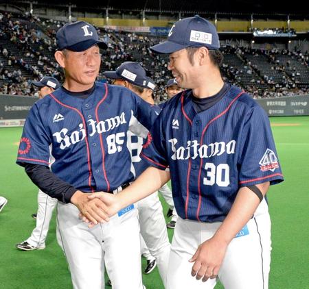 　１１勝目を挙げ、辻監督（左）と握手を交わす西武・榎田
