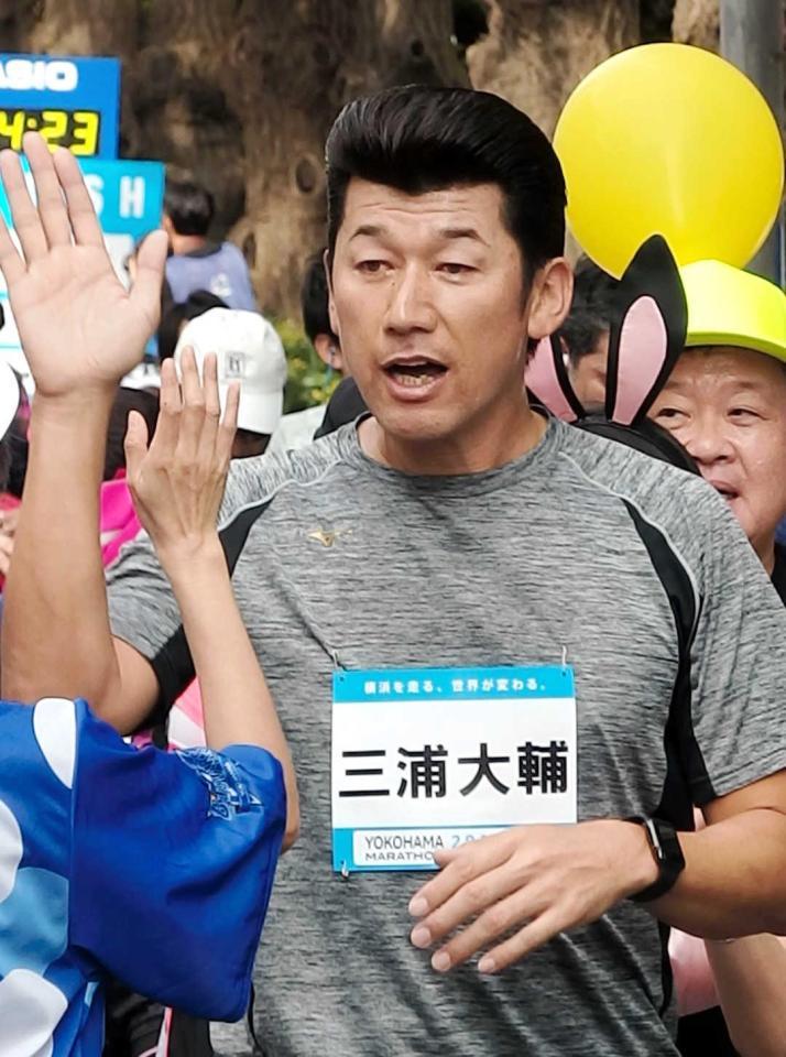 　１／７マラソンのゴール後、参加ランナーとハイタッチを交わす三浦コーチ  
