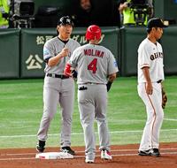 １回、先頭打者安打を放ったサンタナを一塁ベース上で迎える松井ベースコーチ（左）＝撮影・出月俊成