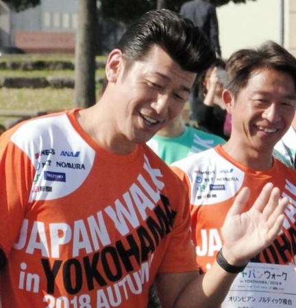 　２０２０年東京五輪イベントで参加者と笑顔でハイタッチを交わす三浦投手コーチ＝横浜・象の鼻パーク